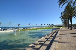 einen Pool mit Palmen am Strand in der Unterkunft SUN and BEACH LOVERS 12019 in La Pineda