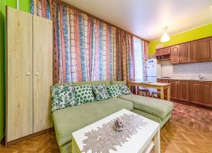 モスクワにあるApartment Hanaka Fortunatovskaya 19のリビングルーム(緑のソファ付)、キッチンが備わります。