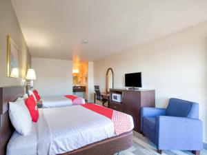 A bed or beds in a room at OYO Woodland Hotel and Suites