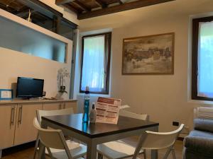 een woonkamer met een tafel en stoelen en een televisie bij Guest House Delizia Estense in Ferrara