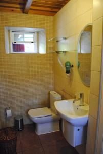 a bathroom with a sink and a toilet and a mirror at Casas Da Faja in Praia do Norte
