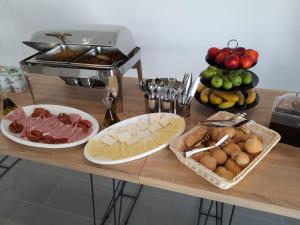 una mesa con queso y otros alimentos. en H&M Hotel, en Vlorë