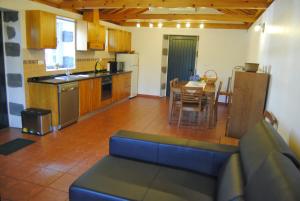 a kitchen with a couch and a table in a room at Casas Da Faja in Praia do Norte