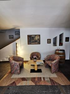 a living room with two chairs and a table at Hotel Eden Guesthouse in Marlengo