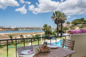 a table with a plate of food on top of a balcony at One Bedroom Sea View Apartment Clube Rio Ferragudo in Ferragudo