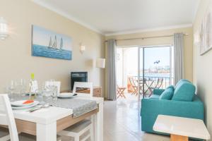 una sala da pranzo e un soggiorno con tavolo da pranzo di One Bedroom Sea View Apartment Clube Rio Ferragudo a Ferragudo