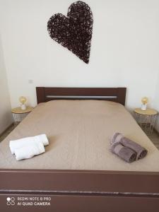 Vico的住宿－Sagone，一张带两条毛巾的床和墙上的心