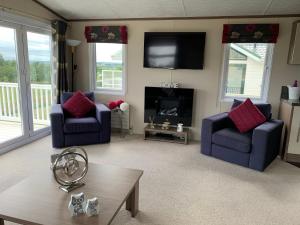 a living room with two chairs and a fireplace at Valley View in Swarland