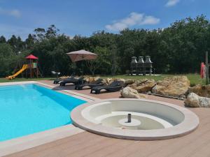 a pool with chairs and a playground with a slide at PÉROLA D'ÓBIDOS t2 in Óbidos