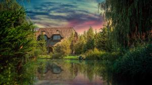 a painting of a house next to a river at Etno Village Cardaci in Vitez