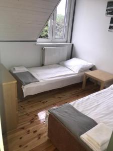 a bedroom with two beds and a window at Rybakówka Nad Jeziorem Wicko in Jezierzany