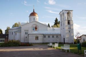 un edificio blanco con una torre y una iglesia en Valamon Luostari, en Uusi-Valamo