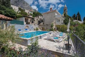 eine Villa mit einem Pool und einem Haus in der Unterkunft Vila Divna in Podgora