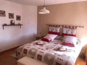 a bedroom with a large bed with red pillows at Le CLOS DE L AMANDIER in Château-Chalon