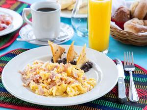a plate of eggs and nachos on a table at Hotel Villa Del Sol Expo in Guadalajara