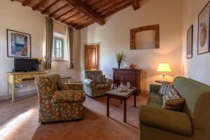 ein Wohnzimmer mit einem Sofa, Stühlen und einem Tisch in der Unterkunft Agriturismo Concadoro in Castellina in Chianti