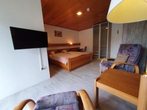a bedroom with a bed and a table and chairs at Pension Robin Hood in Willingen