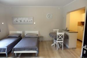 Zimmer mit 2 Betten, einem Tisch und einer Theke in der Unterkunft Spacious Izola Apartment SL in Izola