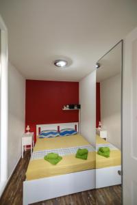 a bedroom with a bed and a red wall at Black and White chill out in Komiža