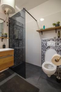 a bathroom with a toilet and a shower at Black and White chill out in Komiža