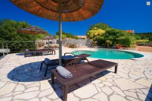 
a pool with a bench and a chair in it at Stone Cottages in Khalikerí
