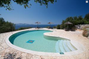 a large swimming pool in the middle of a beach at Stone Cottages in Khalikerí