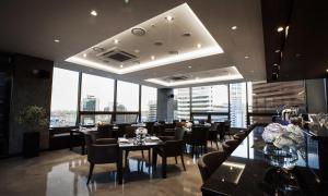 a restaurant with tables and chairs and large windows at Fraser Place Namdaemun Seoul in Seoul