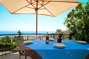 a table with a blue table cloth and an umbrella at casa vista mare con wifi, AC nelle 4 camere da letto e parcheggio privato in Imperia