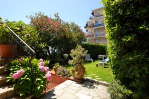 a garden with flowers and plants and a building at Villa Sole in Imperia