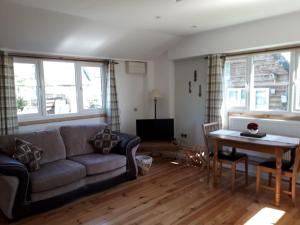 a living room with a couch and a table at Bank Farm House in Chirbury