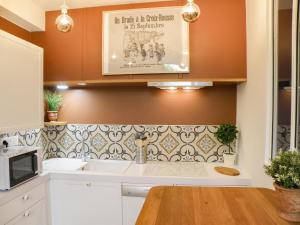 a kitchen with a sink and a microwave at Le Petit Canut - Lyon Centre avec Terrasse - Majord'Home in Lyon