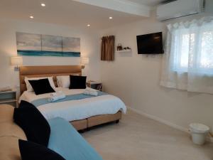 a bedroom with two beds and a flat screen tv at Migdal Luxury Suites Netanya J29 in Netanya