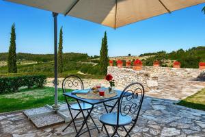 einen Tisch und Stühle unter einem Sonnenschirm auf einer Terrasse in der Unterkunft Agriturismo Concadoro in Castellina in Chianti