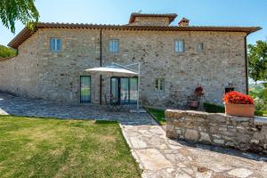 an external view of a stone house with an umbrella at Agriturismo Concadoro in Castellina in Chianti
