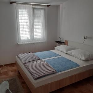 1 cama en un dormitorio con 2 ventanas en Apartments Samaržija- new 63 not 47, en Bibinje