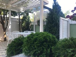 a patio with a table and chairs under a pergola at Vila Sofia in Eforie Nord +13 photos