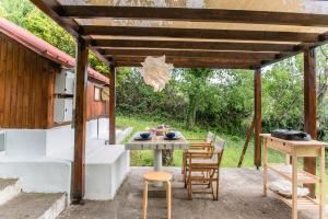 un patio con mesa y sillas bajo una pérgola en #Pinetree Cabin by halu! Villas, en Kalandra