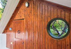 a round window on a wooden wall in a house at #Pinetree Cabin by halu! Villas in Kalandra
