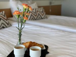a tray with two cups of coffee and a vase with flowers at Park Hotel Tornio in Tornio