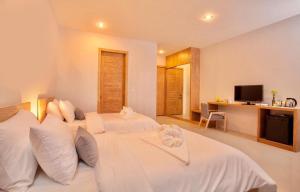 a bedroom with two white beds and a television at Lemonade Phuket Hotel -SHA Plus in Chalong