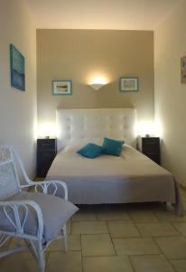 Un dormitorio con una gran cama blanca y una silla. en APPARTEMENTS DANS VILLA EN REZ DE JARDIN, en Hyères 39 fotos más