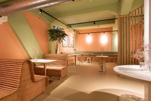 un ristorante con panche e tavoli in una stanza di Pink Flamingo Boutique Hostel a L'Aia