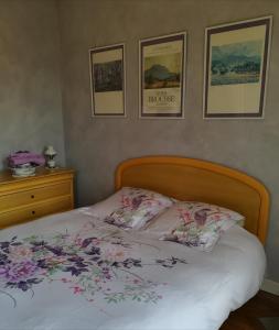 um quarto com uma cama com flores em la villa des chats em Andrésy