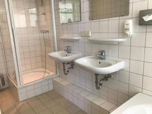 a bathroom with two sinks and a shower at Fletcher Strandhotel Renesse in Renesse