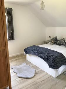 a bedroom with a bed with a black and white blanket at Meadow view apartment in Carncastle