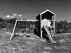 a playground with a slide and a play house at Meadow view apartment in Carncastle