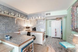 a kitchen with blue and white tiled walls at Beach Suite Sand in Zandvoort