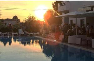 uma multidão de pessoas à volta de uma piscina em Hotel Athina em Velipoja