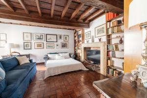 a living room with a blue couch and a tv at Domus Quiritum Charming, Appartamento d'Epoca a Campo de' Fiori in Rome