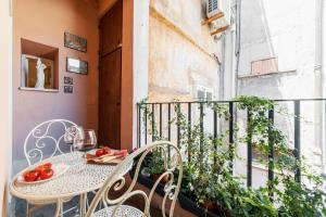 a balcony with a table and chairs on a balcony at Domus Quiritum Charming, Appartamento d'Epoca a Campo de' Fiori in Rome